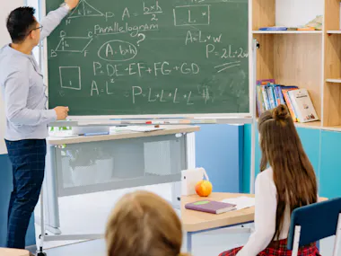 Man doing math on chalkboard.