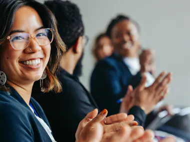 Group of men and women clapping.